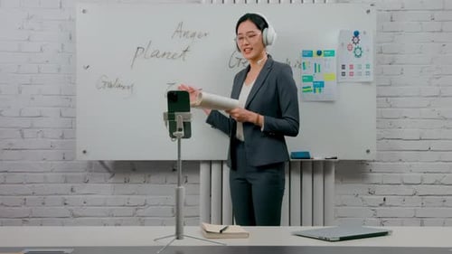 Portrait of self-confident businesswoman glasses standing in the office at the desk with a headset,