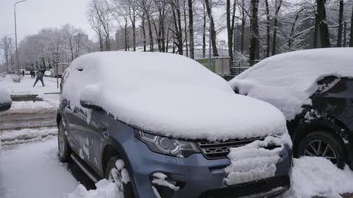 Snowcovered Cars in the Courtyard of a Modern Multistorey Residential Complex