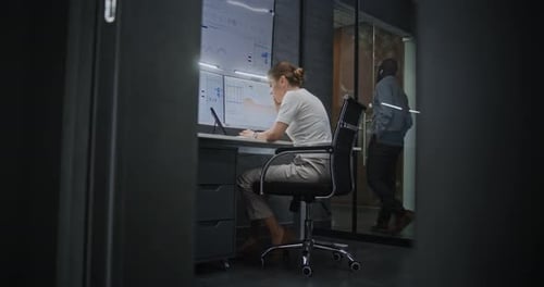 Female Financial Analyst Having Phone Call Analyzing RealTime Stocks on MultiMonitor Computer