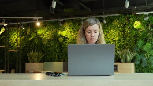 Woman Usinf Laptop in Cafe Freelancer in Coworking