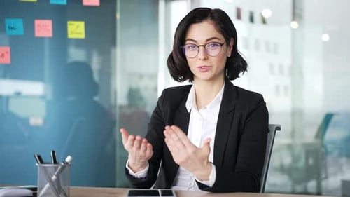 Webcam view. Confident businesswoman communicating on video call using laptop in modern office.