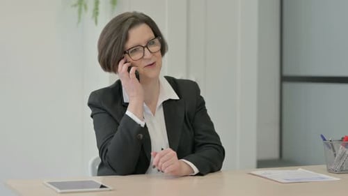 Old Businesswoman Talking on Phone in Office