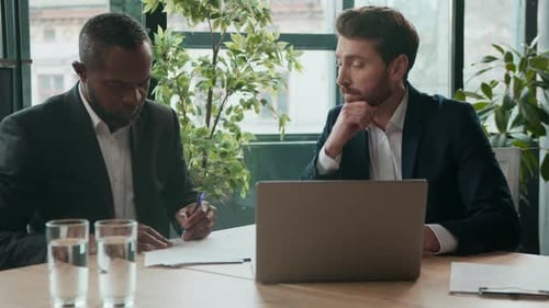 Two businessmen meeting discussing strategy in office