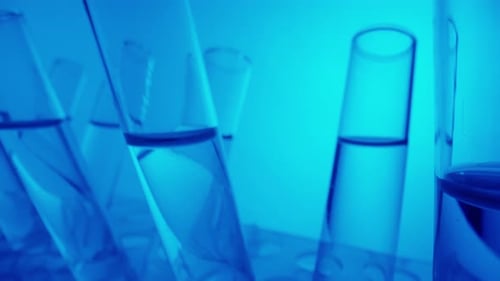 Close Up Video Neon Blue Light Test Tubes Filled with Fluid in a Laboratory Scientific Experiment