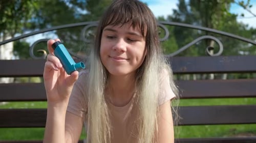 Young Woman Holding Asthma Inhaler Outdoors