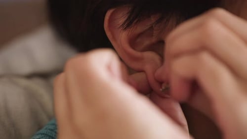 Close Up of Person Putting On Hoop Earring