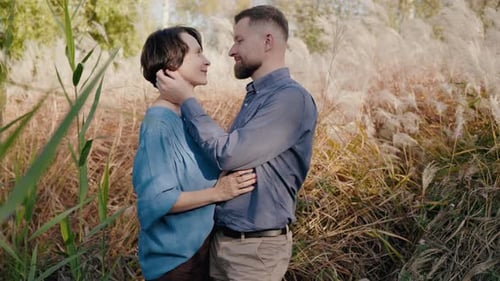 Affectionate Couple Embracing in Golden Field at Sunset