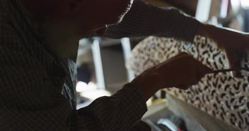 Close up of a carpenter while he is bucking a wooden board after he finished to cut it. Concept: W