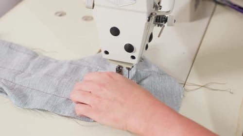 Hand View Tailor retire le matériau du fil à couper à l'aiguille avec précision