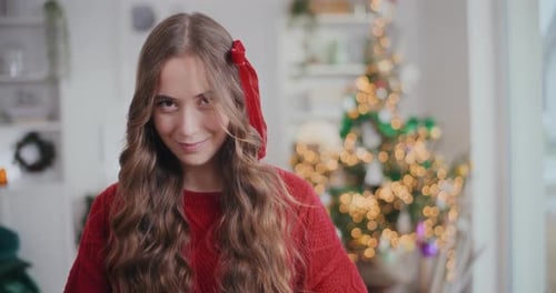 Smiling Young Woman Near Christmas Tree