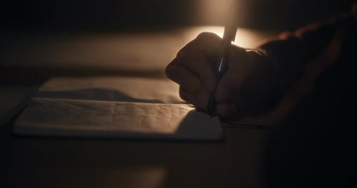 Senior Manager Writing in Notepad at Desk in Office