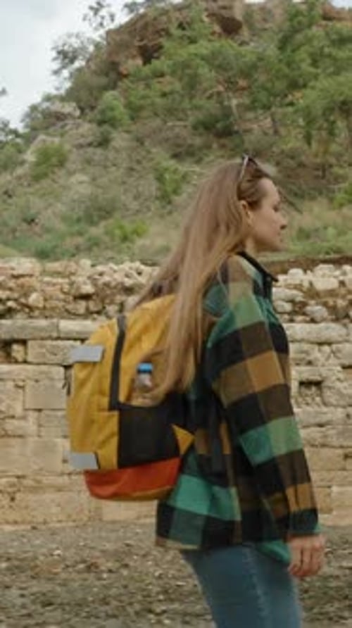 Woman Exploring Ruins in Nature with Backpack