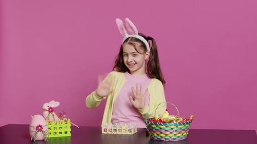 Girl with Bunny Ears Waving in Studio