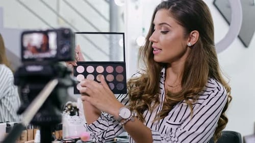 Young female blogger making a video for her beauty blog on cosmetics.