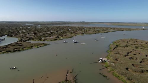 Yacht Sailing Across The River Blackwater With Salt Marshes In Tollesbury Marina, Essex, United King