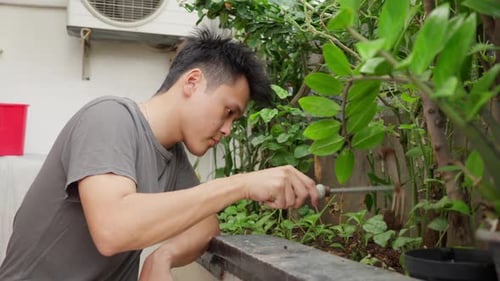 Person using the tines of a fork to dig in a small garden