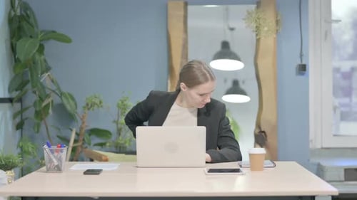 Young Adult Woman Experiencing Back Pain at Desk