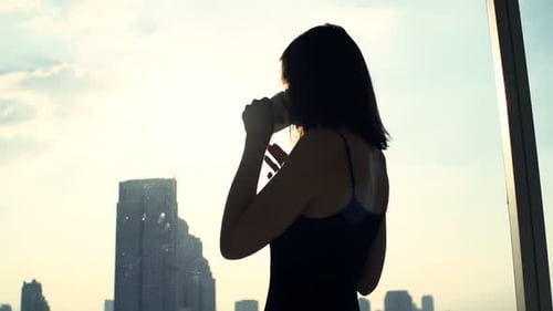 Young Woman Drinking Coffee and Admire View From Window at Home 30s