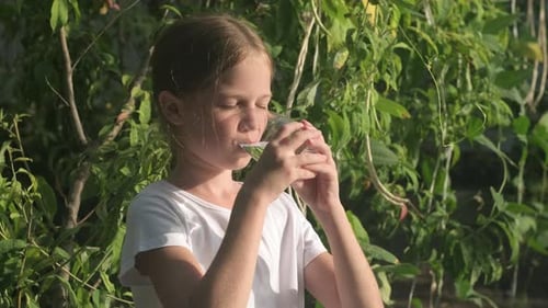 Girl Drinks Water Glass Outdoors in Sunlight