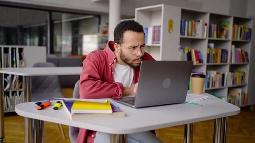 Multiethnic University Graduate Using Laptop Surfing Net Doing Research for Graduation Project