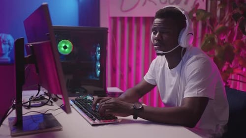 Focused Young Adult Gaming at Neon Lit Desk