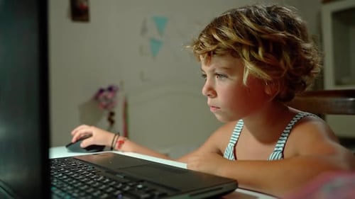 Caucasian Child School Boy or Girl Studying at Home Using Laptop Remote Education in Evening in Room