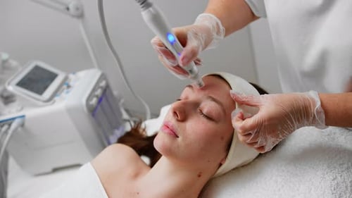 Woman Receiving Facial Treatment in Cosmetic Clinic