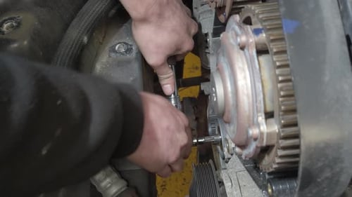 A ratchet and extension being used to tighten a timing belt