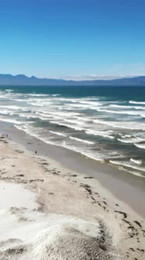 Scenic Seaside Aerial Perspective Unobstructed Drone Shot Capturing Coastal Scene with Dunes and Sea