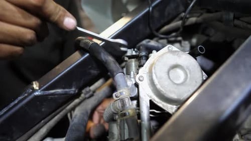 Man Using Wrench to Work on Engine