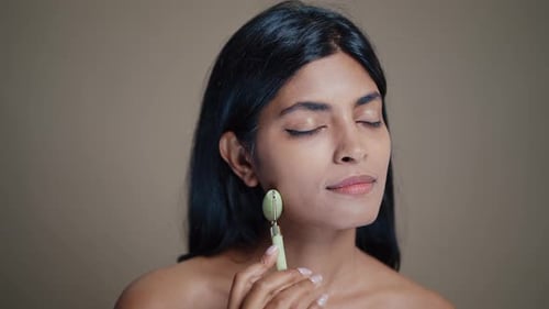 Woman Massaging Face with Jade Roller for Beauty