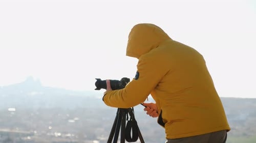 Photographer Using Camera and Tripod To Capture Cityscape