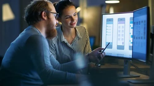 Handsome Male and Beautiful Female Mobile Application Designers Test and Discuss New App Features.