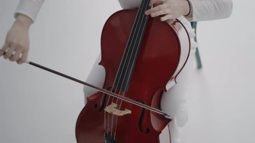 Elegant Woman Playing Cello in White Studio