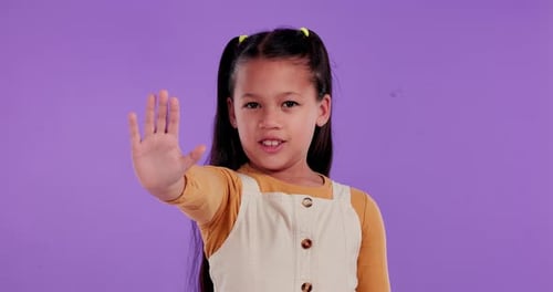 Girl Holds Hand Up in Stopping Gesture