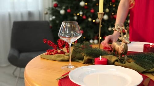 Woman Arranges Festive Christmas Table Setting at Home