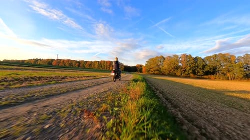 Woman Riding a Motorcycle on a Country Road in Autumn