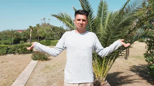 Man Standing in Tropical Urban Park on Sunny Day