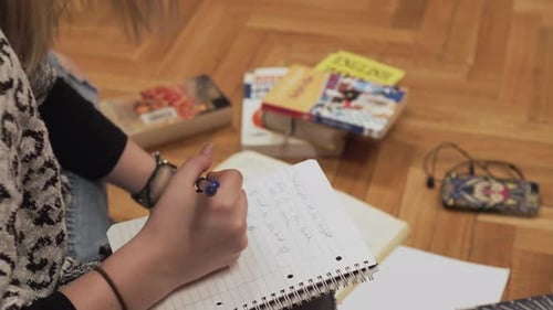 Student Writes in Notebook Studying on the Floor
