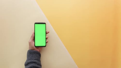 Top View of Young Man Hand Using Smart Phone with Green Screen