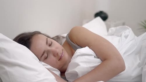 Woman Sleeping Soundly in White Bed