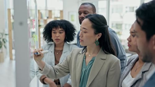 Asian woman, coach and writing on glass board in team brainstorming for schedule planning at office