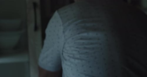 Close-up of an older man heating water in kettle in his home kitchen. Slow Motion 4k.