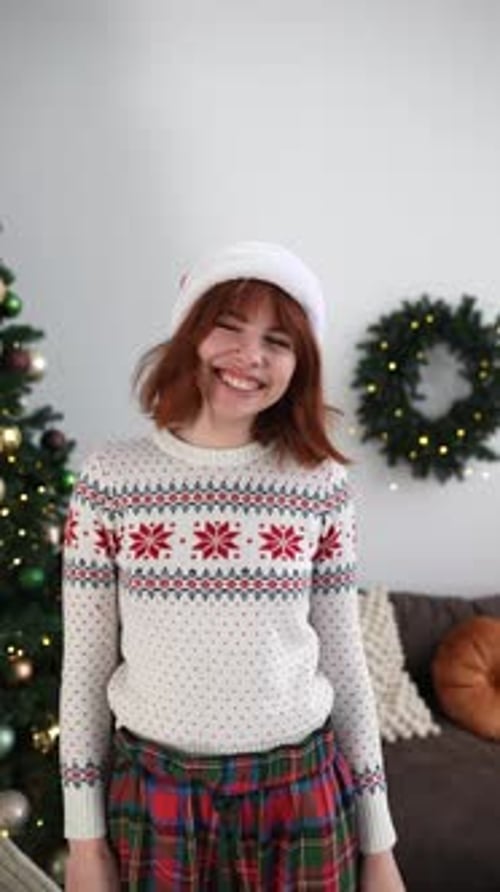 Young Woman Dancing in Christmas Sweater and Santa Hat