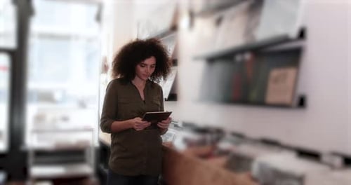 Portrait of small business owner using digital tablet in a record store