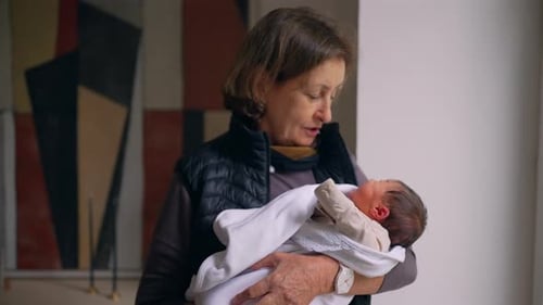 Woman Holds Newborn Baby Indoors