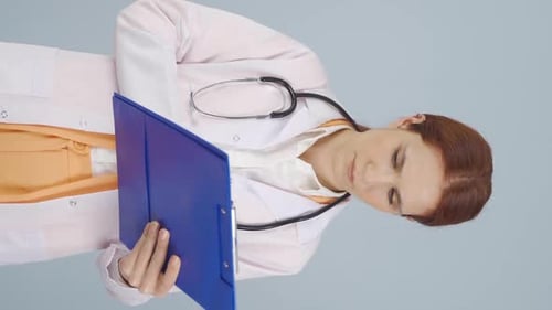 Vertical video of The doctor examining the paperwork is thoughtful.