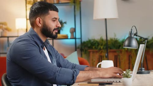 Happy Indian Man Freelancer Typing Working on Laptop Writing Important Email From Home Office