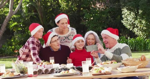 Happy caucasian family having christmas dinner in garden