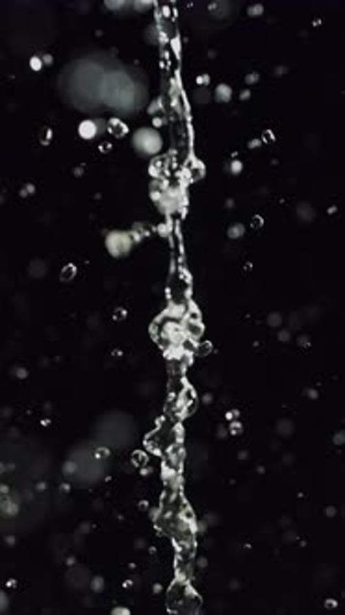 Water Stream Pouring Against Black Background